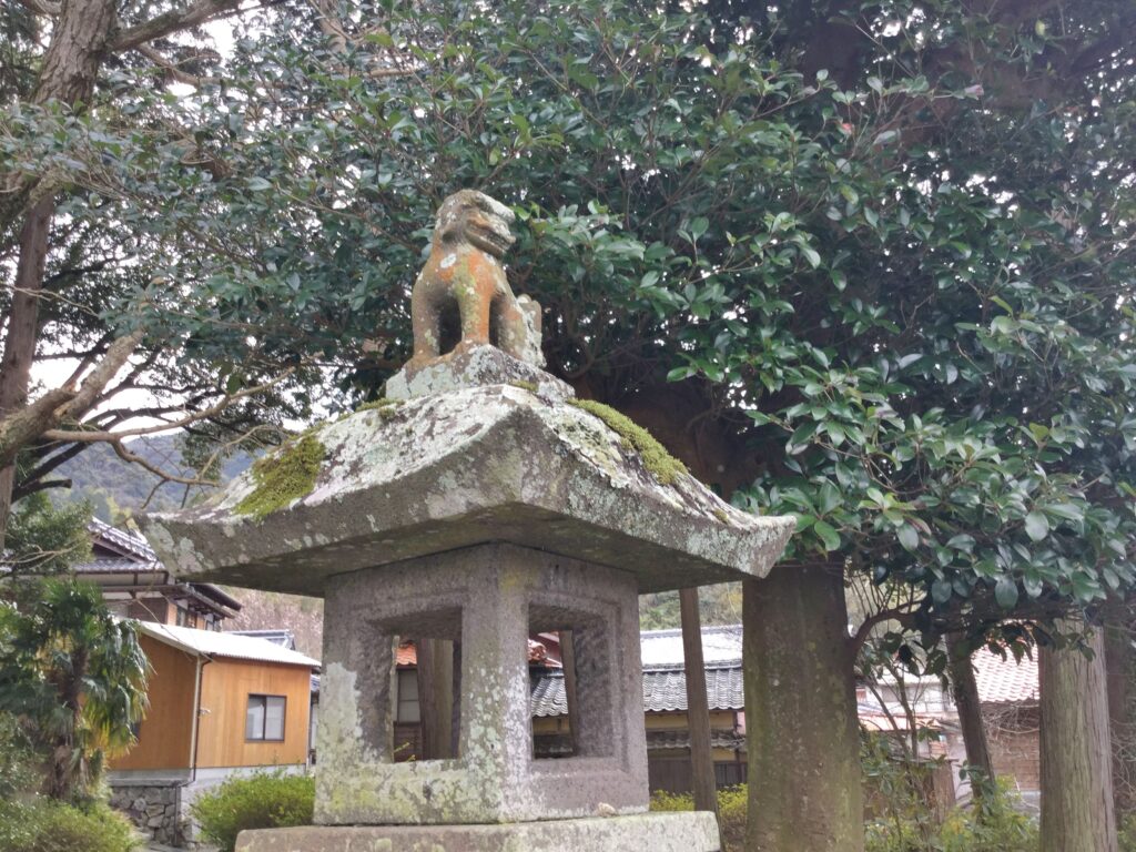 石灯篭の上にいる小さな狛犬